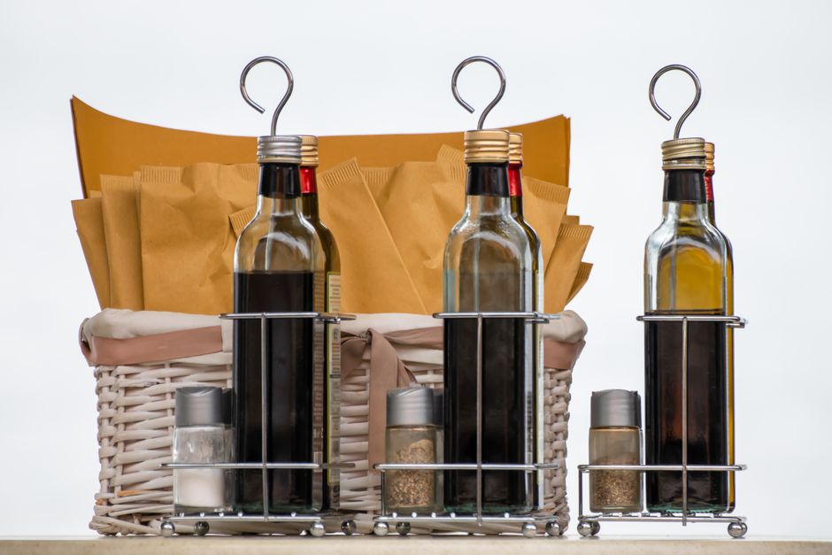 Bottles of vinegar and olive oil in a wire caddy