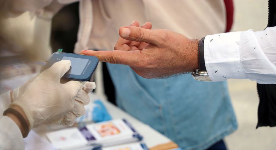A blood glucose monitoring test being performed at a health event