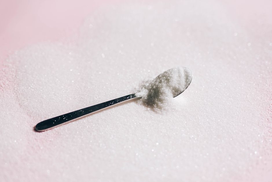 A spoon resting in a pile of granulated sweetener
