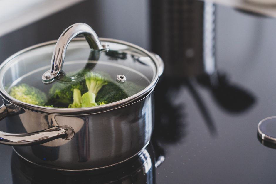 Broccoli steaming in a covered stainless steel pot